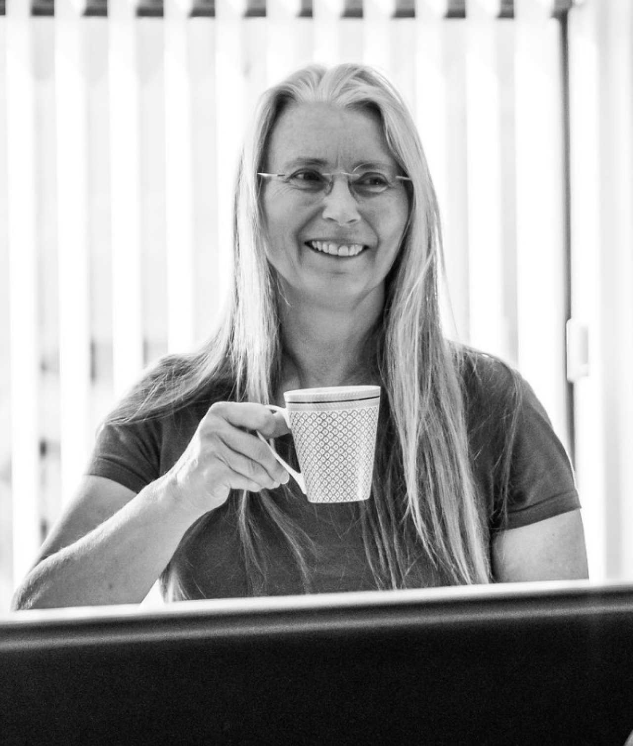 Sarah McMurray smiles with a mug in hand.